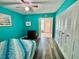 Bright bedroom featuring hardwood floors, ceiling fan, closet and serene blue walls at 2020 World Parkway Blvd # 14, Clearwater, FL 33763