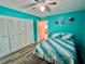 Brightly painted bedroom with closet, ceiling fan, and wood-look flooring at 2020 World Parkway Blvd # 14, Clearwater, FL 33763