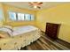 Bedroom featuring yellow walls, hardwood floors, ceiling fan and a window with shutters at 2020 World Parkway Blvd # 14, Clearwater, FL 33763