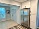 Galley kitchen featuring stainless steel refrigerator and updated white cabinetry at 2020 World Parkway Blvd # 14, Clearwater, FL 33763