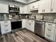 Updated kitchen with white cabinetry, stainless steel appliances, and granite countertops at 2020 World Parkway Blvd # 14, Clearwater, FL 33763