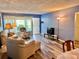 Open concept living room with view to entry door and adjacent dining area at 2020 World Parkway Blvd # 14, Clearwater, FL 33763