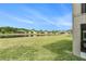 Spacious backyard with lush grass, a scenic pond, and views of neighboring houses at 20251 Ravens End Dr, Tampa, FL 33647