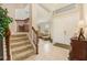 Inviting foyer with staircase, tile flooring, and view into the living room, creating a warm welcome at 20251 Ravens End Dr, Tampa, FL 33647