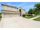 Beautifully landscaped two-story home with a three-car garage, lush green lawn, and freshly painted exterior at 20251 Ravens End Dr, Tampa, FL 33647