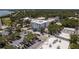 Aerial view showcases a four-story condo building with nearby parking, surrounded by lush greenery and neighborhood streets at 231 2Nd S St # 201, Safety Harbor, FL 34695