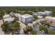 An aerial view of a white, modern condo building, surrounded by parking and lush greenery in a vibrant community at 231 2Nd S St # 201, Safety Harbor, FL 34695