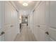 Hallway with a row of white doors that lead to a bathroom with a modern soaking tub at 231 2Nd S St # 201, Safety Harbor, FL 34695