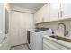 Well-organized laundry area includes modern machines and ample storage cabinets at 231 2Nd S St # 201, Safety Harbor, FL 34695