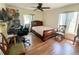 Inviting bedroom with warm hardwood floors; well-lit with fan, desk and chair at 2643 Pine Ridge S Way # A1, Palm Harbor, FL 34684