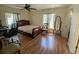 Sunny bedroom with hardwood floors and natural light; featuring window and a mirror at 2643 Pine Ridge S Way # A1, Palm Harbor, FL 34684