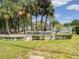 Community entrance sign amidst lush trees and landscaping at 2643 Pine Ridge S Way # A1, Palm Harbor, FL 34684