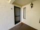 Front entryway featuring a welcome mat, exterior sconce, and textured wall finish at 2643 Pine Ridge S Way # A1, Palm Harbor, FL 34684