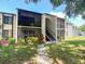 Inviting condo with screened balconies, mature landscaping, and a charming walkway to the entrance at 2643 Pine Ridge S Way # A1, Palm Harbor, FL 34684