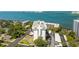Aerial view showcasing the condo building nestled among lush greenery, a pool, and convenient parking areas with bay views at 30 Turner St # 802, Clearwater, FL 33756