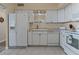 This bright kitchen features white cabinets, white appliances, and tile flooring at 30 Turner St # 802, Clearwater, FL 33756