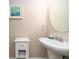 A powder room with a white pedestal sink, round mirror, neutral paint and decorative accents at 311 Vista Cruiser Ln, Oldsmar, FL 34677