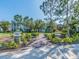 Picturesque community entrance with lush landscaping, brick pathways, and views of colorful residential homes at 311 Vista Cruiser Ln, Oldsmar, FL 34677