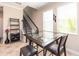 The dining area features a modern glass table with black chairs, wine storage, and a view of the staircase at 311 Vista Cruiser Ln, Oldsmar, FL 34677