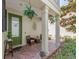 Cozy front porch with brick flooring, potted plants, and comfortable seating for relaxing outdoors at 311 Vista Cruiser Ln, Oldsmar, FL 34677