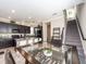 A modern kitchen with an island and granite countertops is located next to the dining area and staircase at 311 Vista Cruiser Ln, Oldsmar, FL 34677