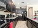Stylish kitchen featuring dark cabinets, granite counters, stainless appliances, and ample storage space at 311 Vista Cruiser Ln, Oldsmar, FL 34677