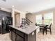 A kitchen island with granite countertop, stainless steel sink and dark cabinets, next to the dining area and staircase at 311 Vista Cruiser Ln, Oldsmar, FL 34677