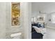 Stylish half-bathroom featuring a decorative mirror and adjacent view of the living room at 3111 W De Leon St # 8, Tampa, FL 33609