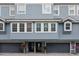 Exterior of a three-story townhome with garage doors, an entryway, and well-lit windows at 3111 W De Leon St # 8, Tampa, FL 33609