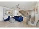 Spacious living room with tile floors, gray accent walls, ceiling fan, and a large blue sectional sofa at 3111 W De Leon St # 8, Tampa, FL 33609