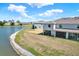 Exterior rear view of a townhome with a screened lanai overlooking a tranquil lake at 33030 Major Oak Dr, Wesley Chapel, FL 33545