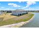 Backyard view of a light gray townhome with a screened in patio and lake view at 33030 Major Oak Dr, Wesley Chapel, FL 33545