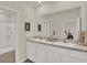Bathroom featuring dual sinks, a large mirror, and an adjacent shower/tub area at 33030 Major Oak Dr, Wesley Chapel, FL 33545
