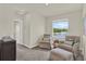 Bright bedroom with comfortable seating, a serene lake view, and carpeted floors at 33030 Major Oak Dr, Wesley Chapel, FL 33545