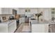 Modern kitchen featuring white cabinets, granite countertops, stainless steel appliances, and tile flooring at 33030 Major Oak Dr, Wesley Chapel, FL 33545