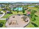 Aerial view of a well-maintained community playground, featuring swings, slides, and play structures at 33030 Major Oak Dr, Wesley Chapel, FL 33545