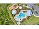Aerial view of the community pool and splashpad with several lounge chairs and tables surrounding the area at 33030 Major Oak Dr, Wesley Chapel, FL 33545