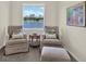 Inviting sitting room with comfortable chairs, a wicker table, and a large window overlooking the lake at 33030 Major Oak Dr, Wesley Chapel, FL 33545