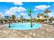 Community splash pad area with palm trees, lounge chairs, and a playground at 33030 Major Oak Dr, Wesley Chapel, FL 33545
