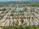 Drone's-eye view of a sprawling residential community with a central lake and lush green surroundings at 3315 Granite Ridge Loop, Land O Lakes, FL 34638
