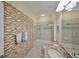 Bathroom with granite vanity, framed mirror, glass enclosed tub and unique tile backsplash at 3315 Granite Ridge Loop, Land O Lakes, FL 34638