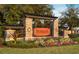 Stonegate community entrance featuring stone pillars, a pergola, and manicured landscaping at 3315 Granite Ridge Loop, Land O Lakes, FL 34638
