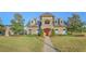 Stunning front elevation view of a luxurious stone home with manicured lawn and garden at 3315 Granite Ridge Loop, Land O Lakes, FL 34638