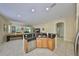 Open-concept kitchen boasts stainless steel appliances, granite countertops, and tile flooring adjacent to a cozy living area at 3315 Granite Ridge Loop, Land O Lakes, FL 34638