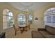 Sunlit office space featuring comfortable seating, a round table, and bright arched windows for a productive work environment at 3315 Granite Ridge Loop, Land O Lakes, FL 34638