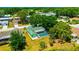 Aerial view of a home with a screened-in pool surrounded by mature trees in a residential neighborhood at 3414 Rankin Dr, New Port Richey, FL 34655