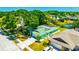 Aerial view featuring a charming green home with solar panels near a tranquil pond at 3414 Rankin Dr, New Port Richey, FL 34655