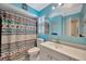 Bright bathroom with light blue walls, patterned shower curtain, and large mirror at 3414 Rankin Dr, New Port Richey, FL 34655