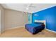 A sunlit bedroom with a blue accent wall, ceiling fan, and hardwood floors at 3414 Rankin Dr, New Port Richey, FL 34655