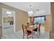 Dining room boasts wood table with centerpiece and elegant chandelier, with sightlines into the adjacent rooms at 3414 Rankin Dr, New Port Richey, FL 34655